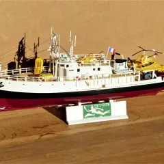 Modell des Forschungsschiffs Calypso mit gelbem Käfig und U-Boot.