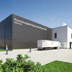 Moderne Gebäude des Fraunhofer FFB in Münster, mit LKW und Personen.