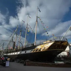 Das historische Schiff SS Great Britain, geschmückt mit bunten Flaggen, liegt im Hafen.
