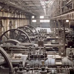 Reihen von riesigen Maschinen mit Schwungrädern in einer Fabrikhalle. Ein Blick in die Zeit, wann war die Industrialisierung?