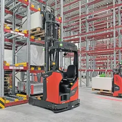 Moderne Lagerhallen mit Regalen und automatisierten Gabelstaplern, die für industrielle Automatisierung stehen.