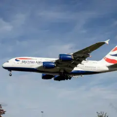 Ein riesiges British Airways Flugzeug mit vier Triebwerken fliegt im blauen Himmel. Wie lang ist ein Flugzeug dieser Größe? Über 70 Meter!