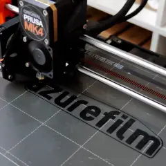 Ein 3D-Drucker wie dieser Prusa MK4 druckt Schicht für Schicht ein Objekt. Hier wird gerade das Logo "azurefilm" gedruckt.