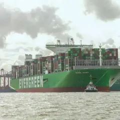 Das riesige Containerschiff "EVER ALOT" liegt im Hafen, beladen mit tausenden von Containern. Ein Schlepper assistiert.