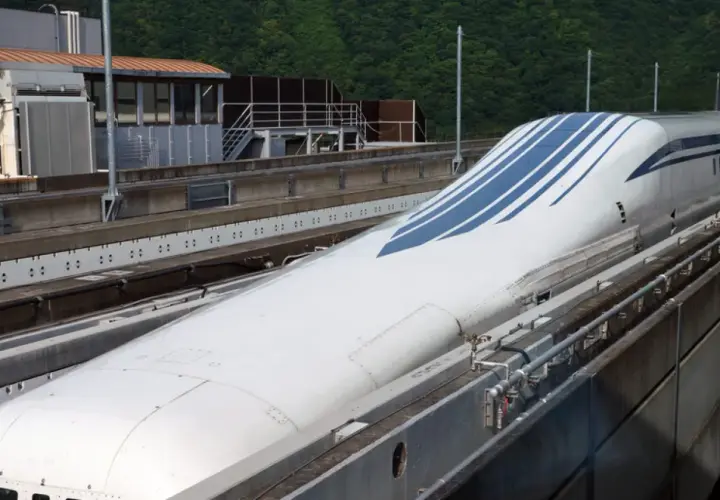 Der schnellste Zug Japans, ein Shinkansen, mit seiner aerodynamischen Nase und blauen Streifen, steht auf den Gleisen.