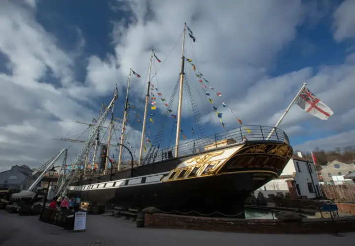 Das historische Schiff SS Great Britain, geschmückt mit bunten Flaggen, liegt im Hafen.
