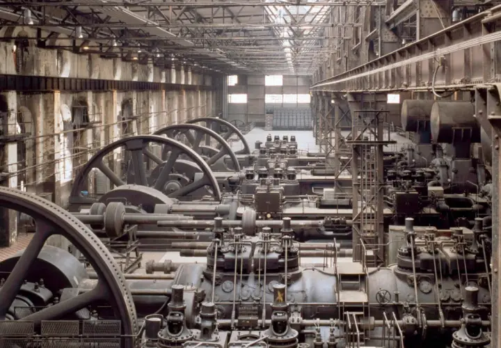 Reihen von riesigen Maschinen mit Schwungrädern in einer Fabrikhalle. Ein Blick in die Zeit, wann war die Industrialisierung?