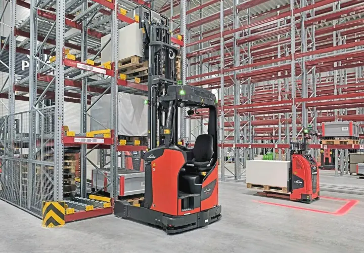 Moderne Lagerhallen mit Regalen und automatisierten Gabelstaplern, die für industrielle Automatisierung stehen.