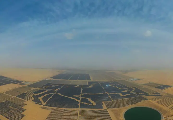 Weites Feld mit Solarmodulen in China, das die Kraft der Sonne nutzt. Ein riesiger Solarpark erstreckt sich über die Wüste.
