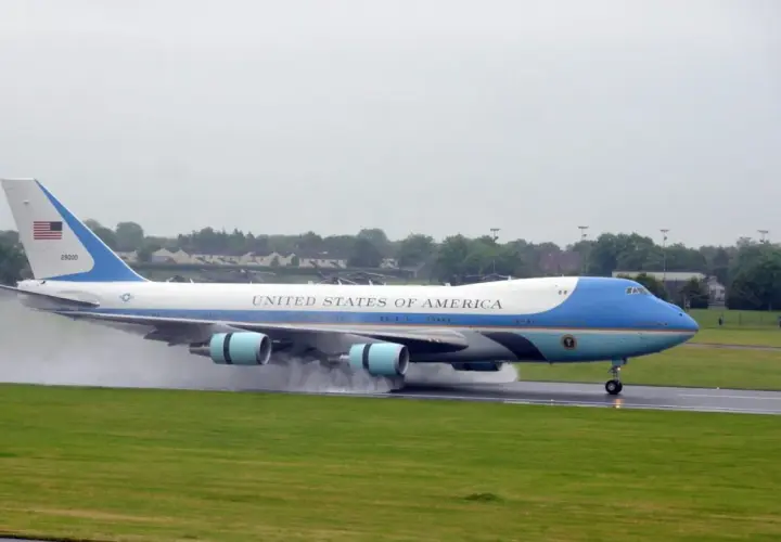 Das Air Force One Flugzeug landet auf einer nassen Landebahn.