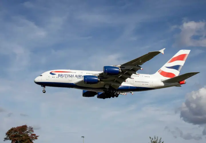 Ein riesiges British Airways Flugzeug mit vier Triebwerken fliegt im blauen Himmel. Wie lang ist ein Flugzeug dieser Größe? Über 70 Meter!
