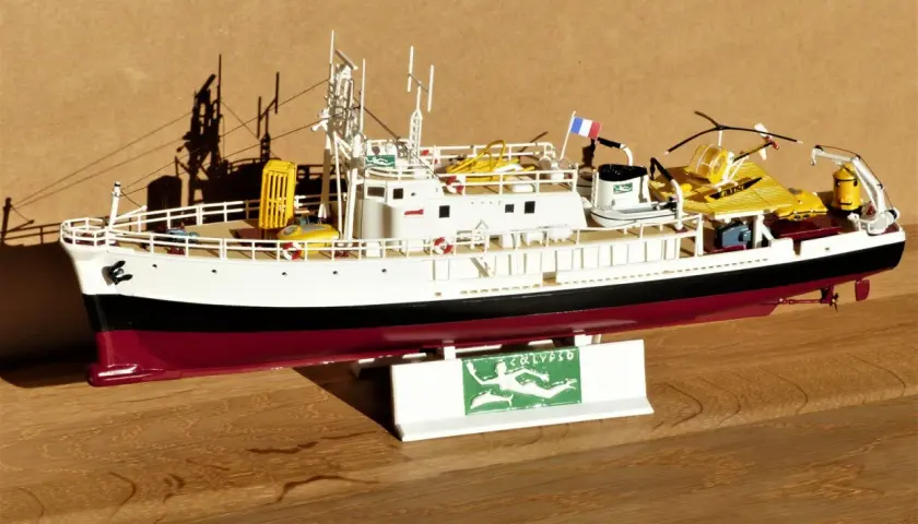 Modell des Forschungsschiffs Calypso mit gelbem Käfig und U-Boot.