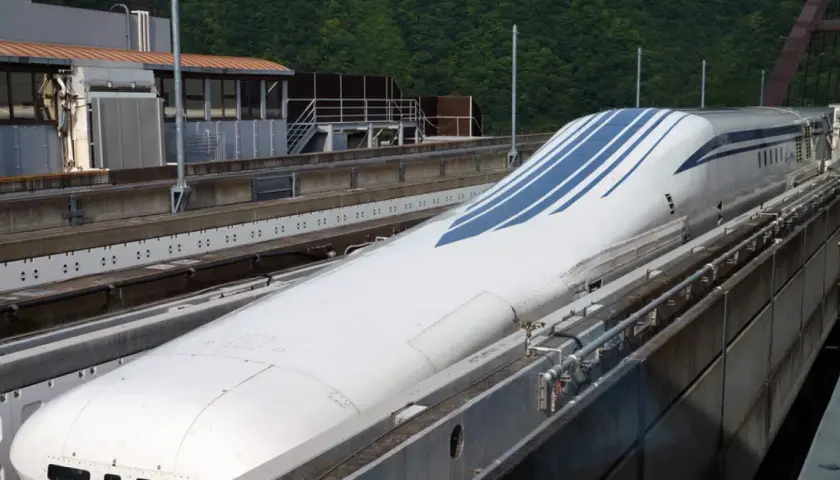 Der schnellste Zug Japans, ein Shinkansen, mit seiner aerodynamischen Nase und blauen Streifen, steht auf den Gleisen.