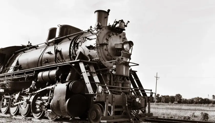 Eine Dampflokomotive, ein Symbol der industriellen Revolution, steht auf Gleisen.