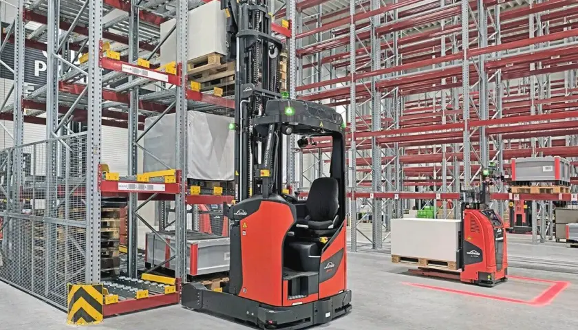 Moderne Lagerhallen mit Regalen und automatisierten Gabelstaplern, die für industrielle Automatisierung stehen.