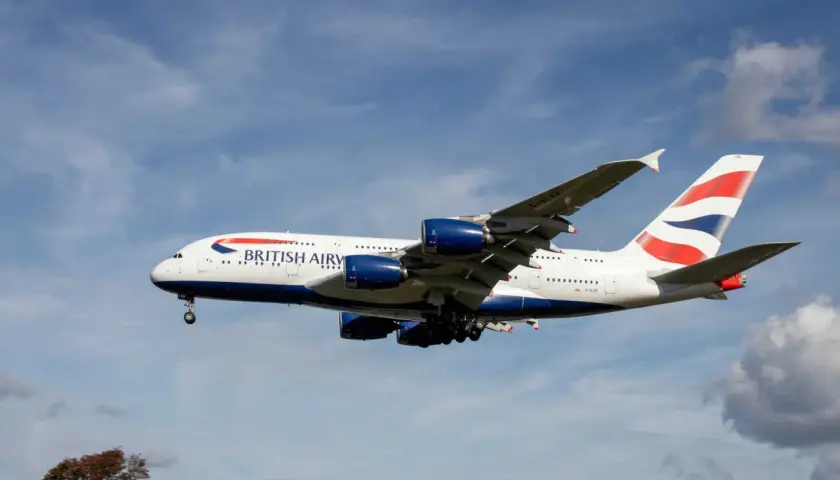 Ein riesiges British Airways Flugzeug mit vier Triebwerken fliegt im blauen Himmel. Wie lang ist ein Flugzeug dieser Größe? Über 70 Meter!