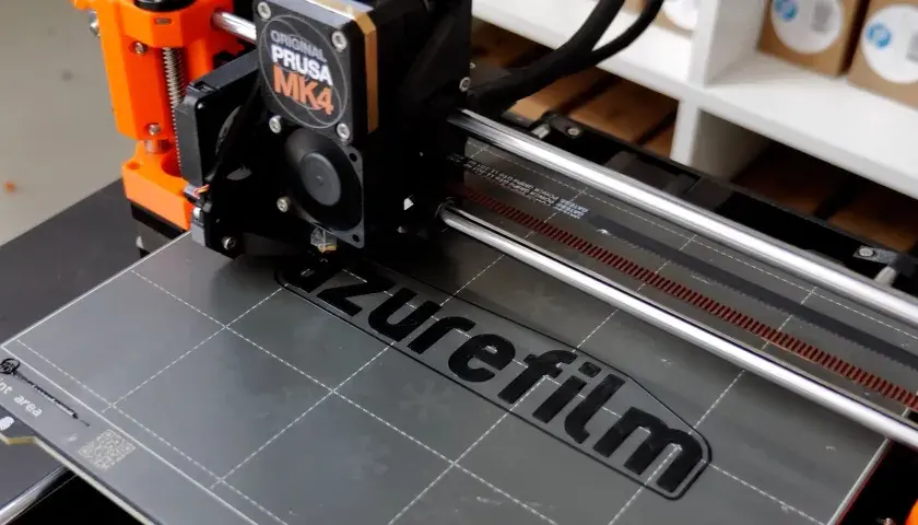 Ein 3D-Drucker wie dieser Prusa MK4 druckt Schicht für Schicht ein Objekt. Hier wird gerade das Logo "azurefilm" gedruckt.