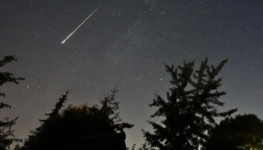 Ein heller Sternschnuppen-Streifen zieht sich über den sternenübersäten Nachthimmel. Perfekt, um die Perseiden zu beobachten.