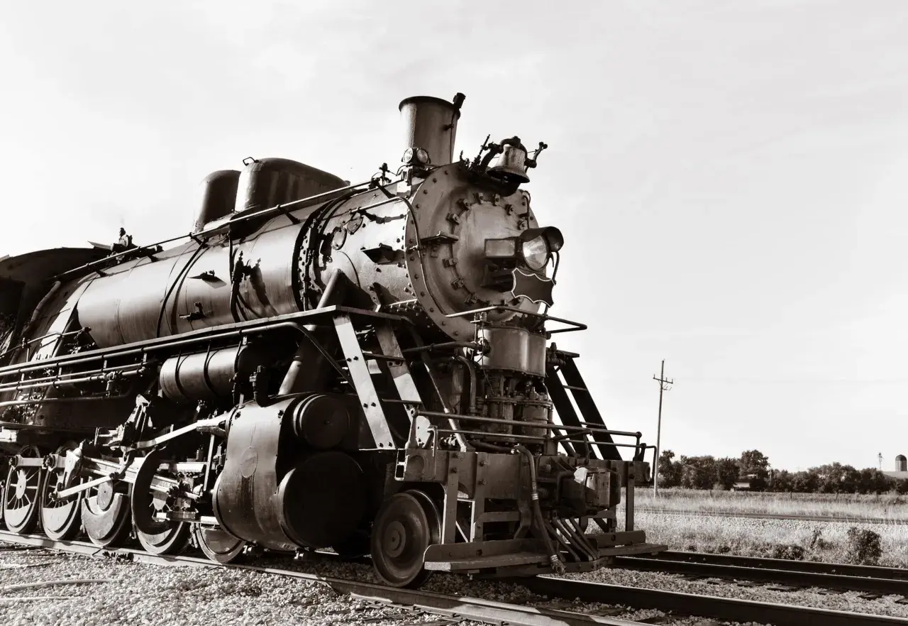 Eine Dampflokomotive, ein Symbol der industriellen Revolution, steht auf Gleisen.