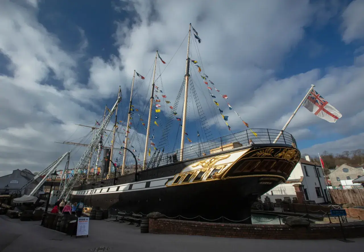 Das historische Schiff SS Great Britain, geschmückt mit bunten Flaggen, liegt im Hafen.
