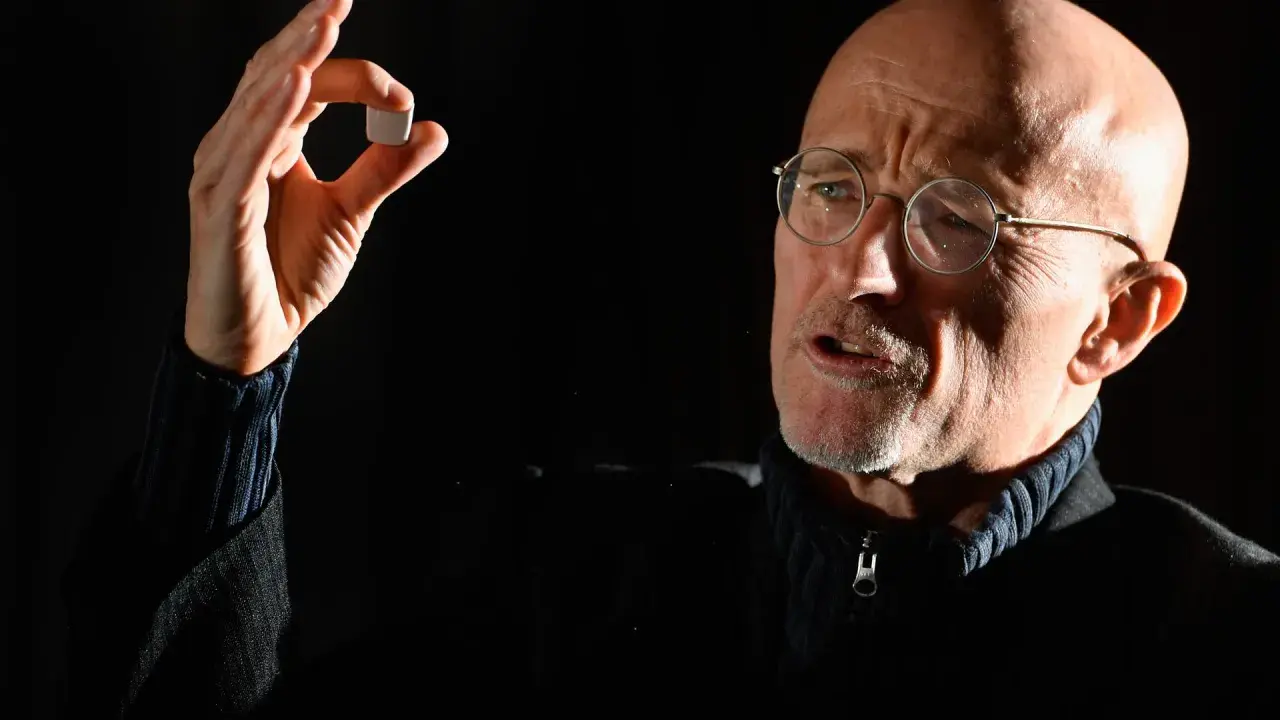 Mann mit Brille hält kleines Objekt, das an eine zukünftige Kopf transplantation erinnert.
