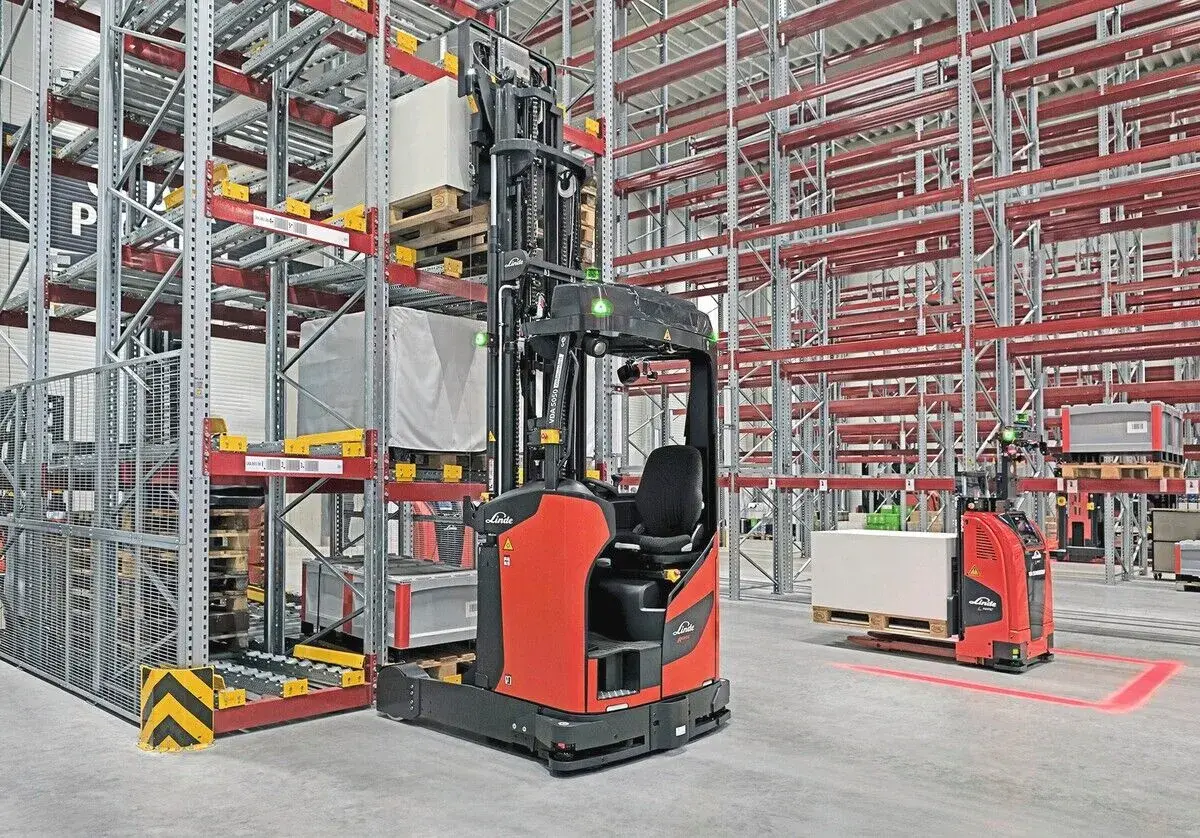 Moderne Lagerhallen mit Regalen und automatisierten Gabelstaplern, die für industrielle Automatisierung stehen.