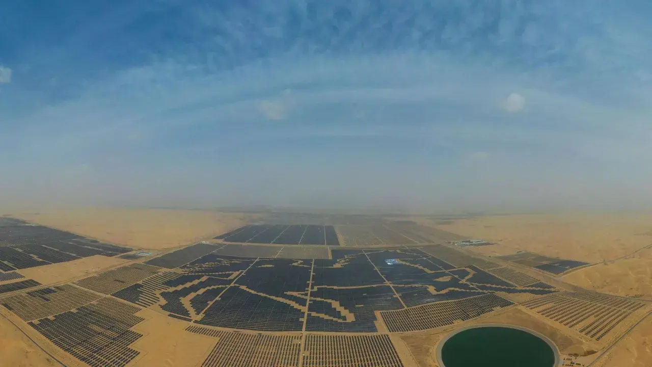 Weites Feld mit Solarmodulen in China, das die Kraft der Sonne nutzt. Ein riesiger Solarpark erstreckt sich über die Wüste.