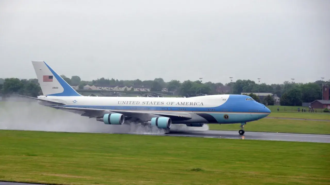 Das Air Force One Flugzeug landet auf einer nassen Landebahn.