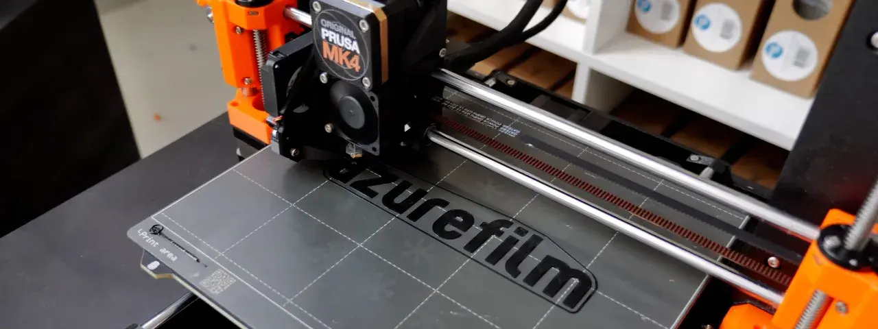 Ein 3D-Drucker wie dieser Prusa MK4 druckt Schicht für Schicht ein Objekt. Hier wird gerade das Logo "azurefilm" gedruckt.