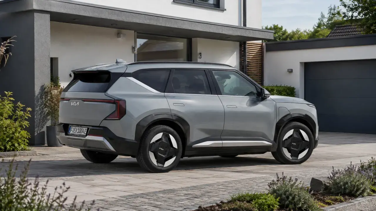 Silbernes Elektroauto der Marke Kia parkt vor einem modernen Haus.