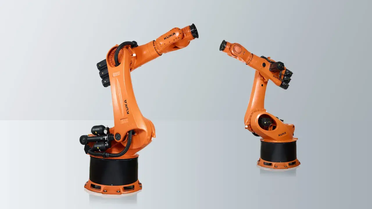 Zwei orange KUKA Roboterarme, die für industrielle Aufgaben konzipiert sind. Hier sieht man, welche Roboter es gibt: leistungsstarke und präzise Maschinen.