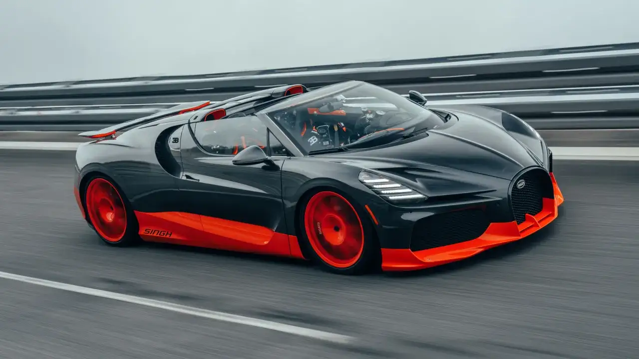 Schwarzer Bugatti mit orangen Akzenten rast &uuml;ber die Stra&szlig;e. Man fragt sich, wie schnell ist ein Bugatti wohl?