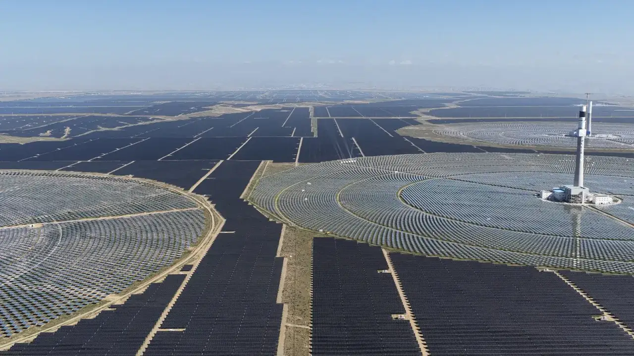 Gigantischer china solarpark erstreckt sich &uuml;ber die Landschaft. Ein zentraler Turm ragt aus einem kreisf&ouml;rmigen Feld von Solarmodulen.