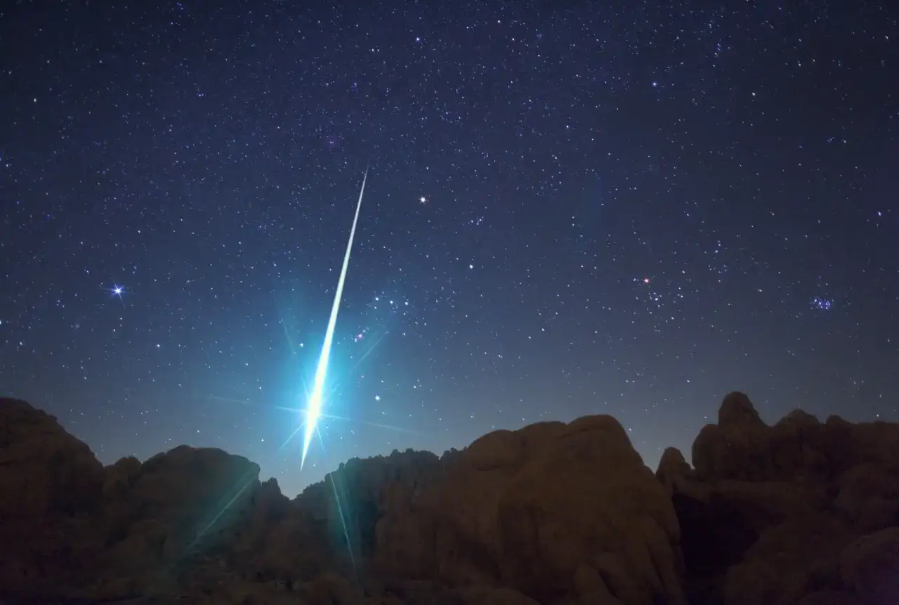 Ein heller Meteor zieht eine leuchtende Spur &uuml;ber den sternen&uuml;bers&auml;ten Nachthimmel. Ein magischer Moment, um Sternschnuppen zu sehen!