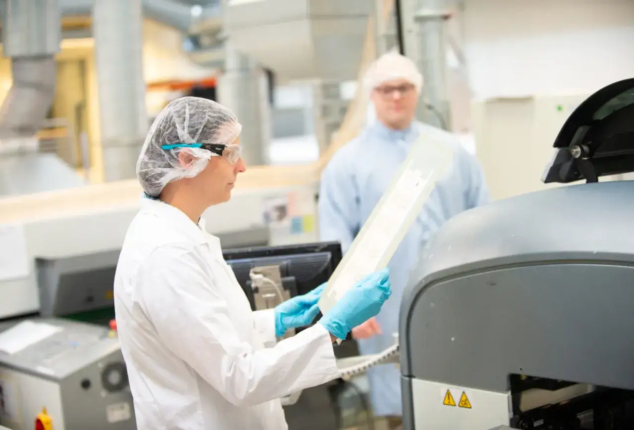 Mitarbeiterin der Holzforschung Austria pr&uuml;ft ein Materialmuster in einem Labor.