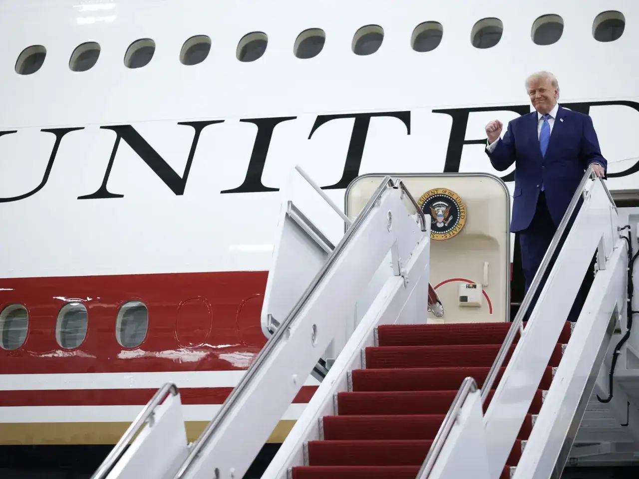 Donald Trump steigt die rote Treppe des Air Force One Flugzeugs hinab.