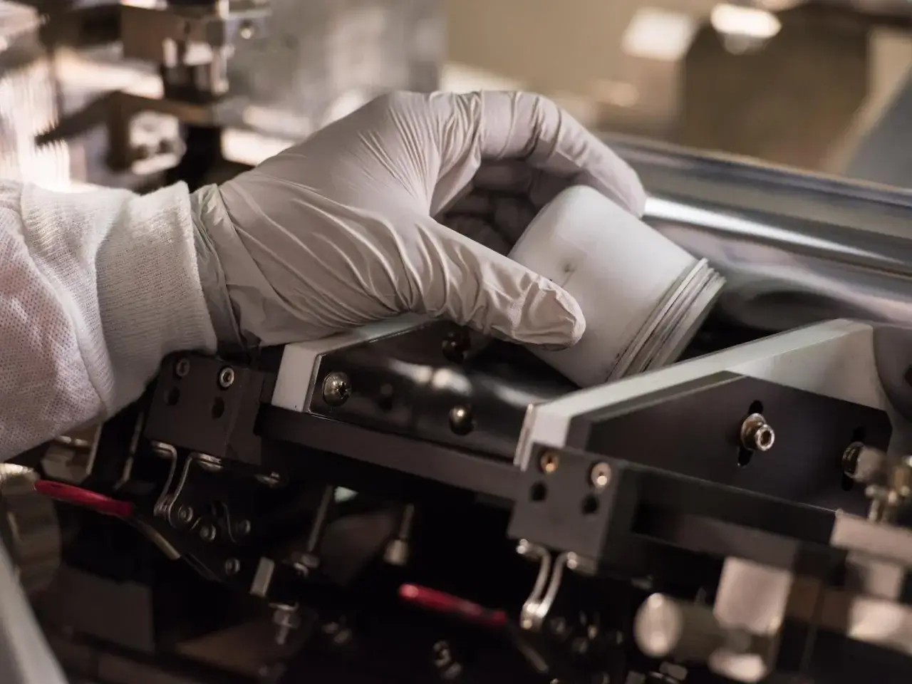 Forscher des Fraunhofer FFB handhaben sorgf&auml;ltig ein wei&szlig;es Gef&auml;&szlig; in einer komplexen Maschine.